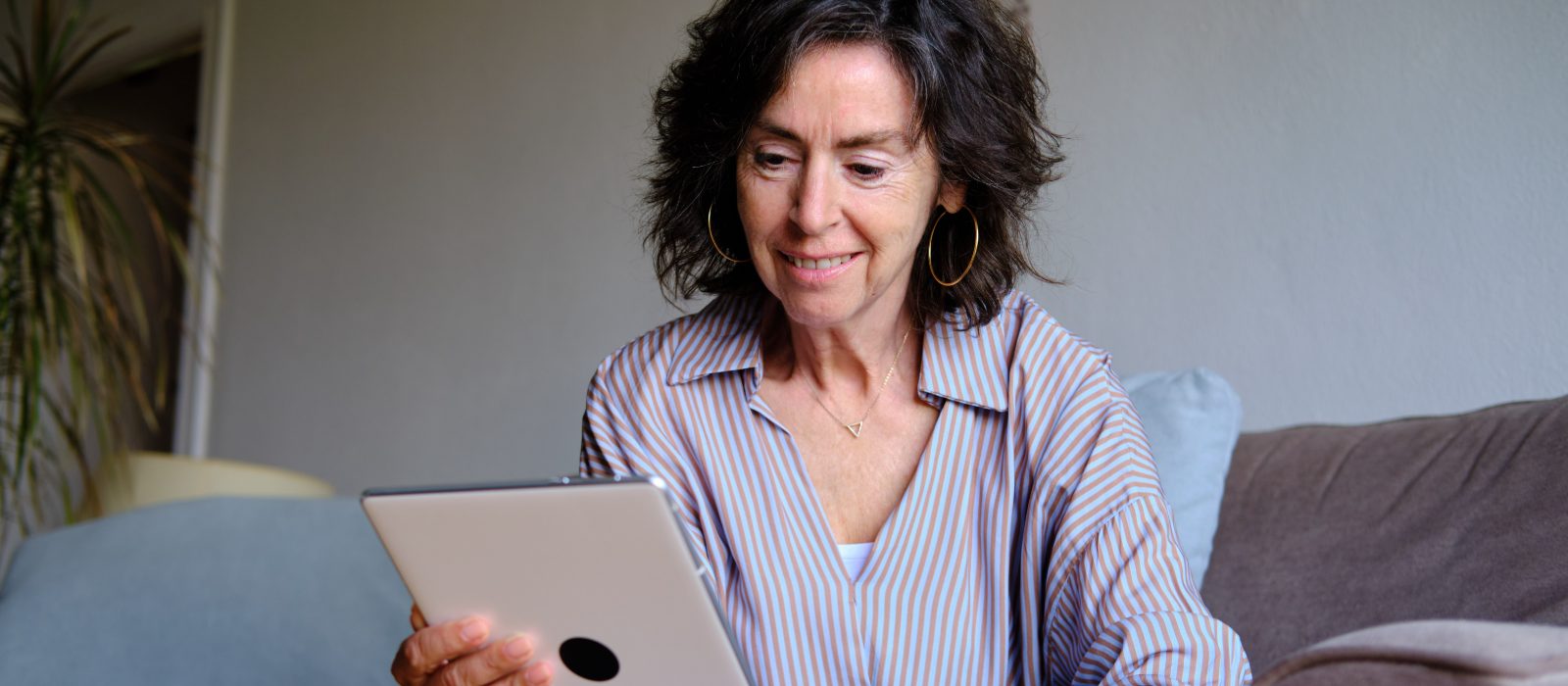 A woman using a tablet at home, relaxed.