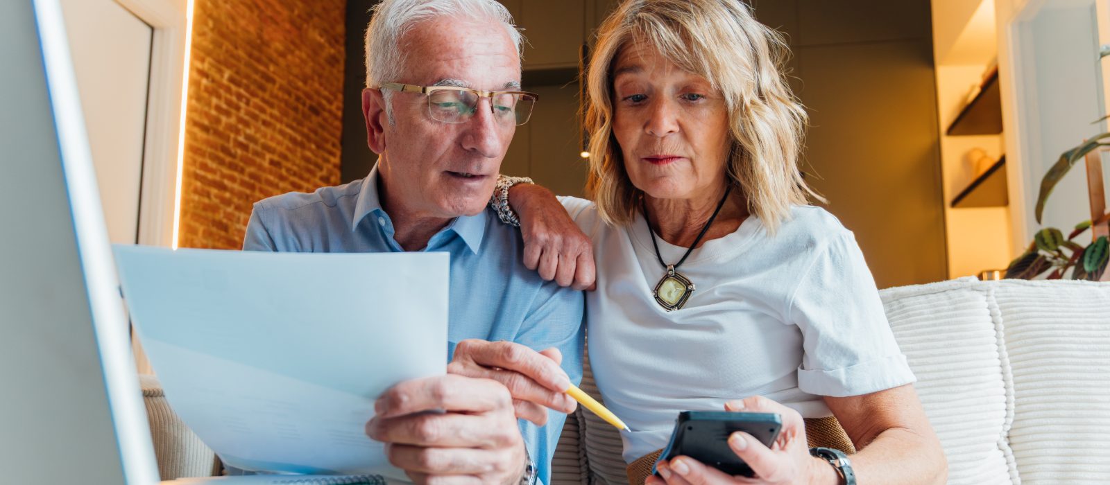 An older couple reviewing a document together at home.